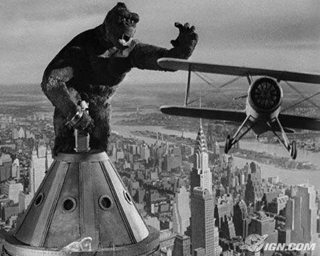 Photo en noir et blanc montrant King Kong au somment de l&#039;empire state building et un avion le menaçant.